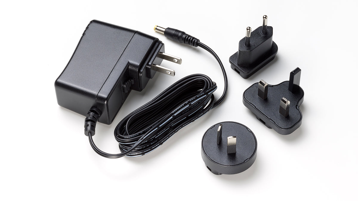 Tascam PS-P1220E 12V AC power adapter for Dante processors, showing the Tascam branded power supply with cord attached.