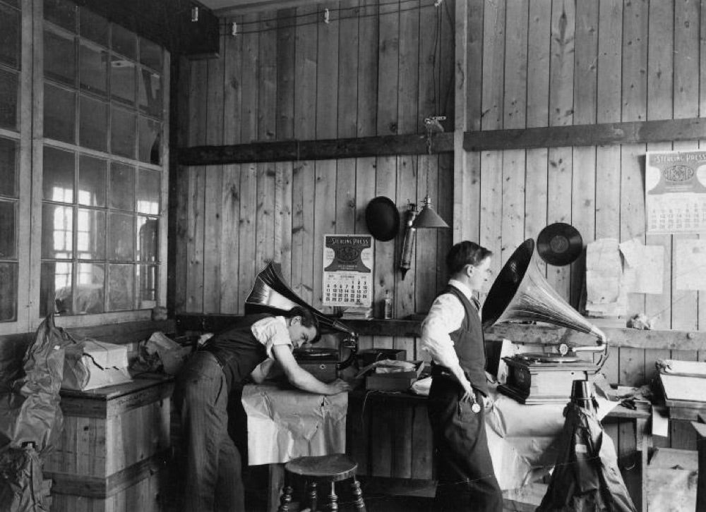 Two workers in the Berliner Gramophone Company workshop in Montreal, 1910, using horn gramophones to inspect pressed records