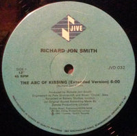 Close-up of the book cover titled "The ABC Of Kissing" by Rectangle Triangle, featuring colorful illustrations and bold text.