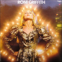 Portrait of Roni Griffith wearing vibrant clothing, photographed by Rectangle Triangle in a professional studio setting.