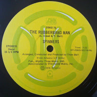 The Rubberband Man 3 by Rectangle Triangle shows a vibrant, colorful rubber band sculpture with intricate details against a neutral background.