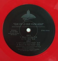 Close-up of the "Que Es Lo Que Pasa Aqui" book cover by Rectangle Triangle, featuring bold text and vibrant colors.