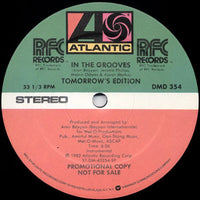 Rectangle Triangle's "In The Grooves" vinyl record with colorful groove patterns on a white background.