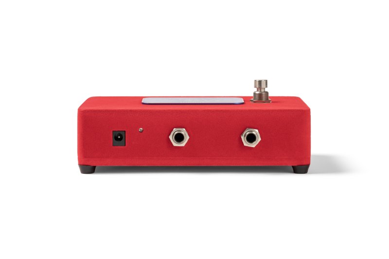 Warm Audio Foxy Tone Box guitar effects pedal in red, featuring fuzz distortion with 9V adapter, compact stompbox design.